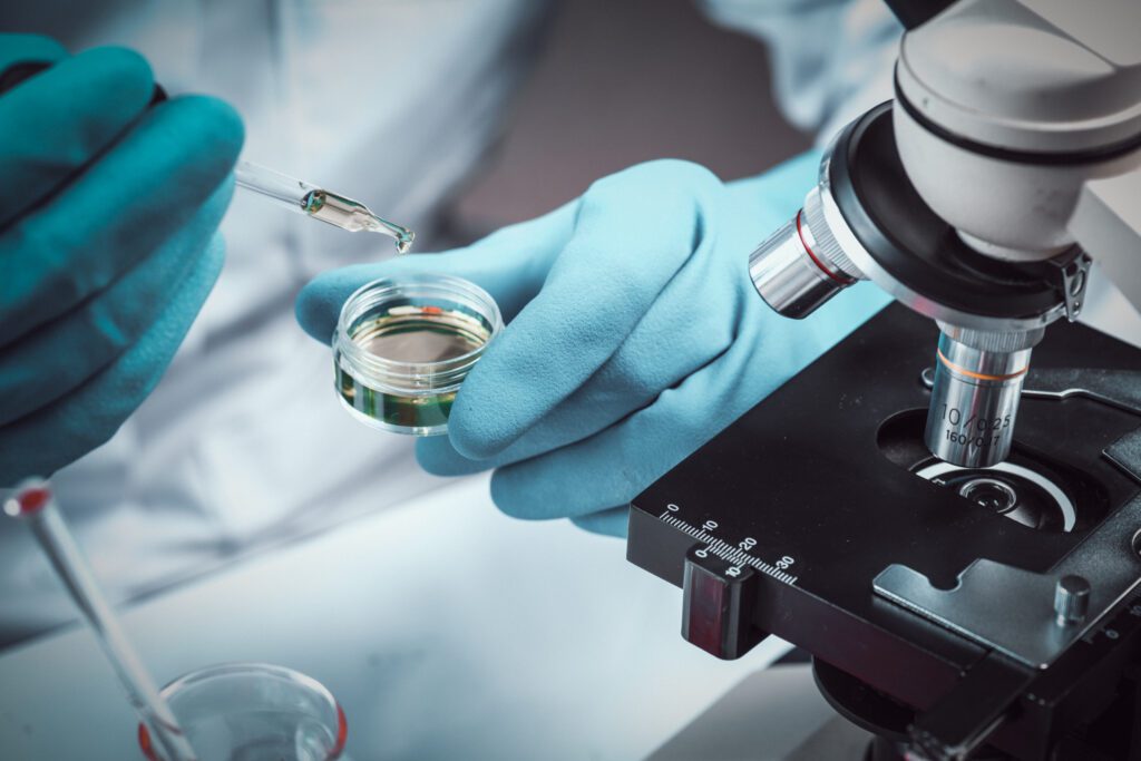 Conical flask in scientist hand with microscope and lab glassware background, Laboratory research concept